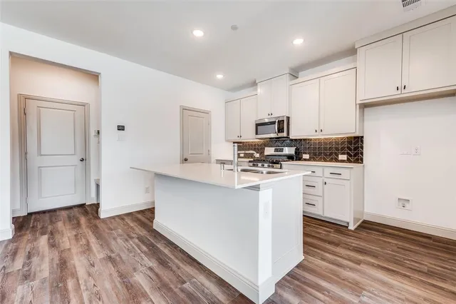 a kitchen with granite countertop white cabinets and stainless steel appliances