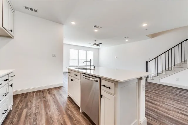 a kitchen with granite countertop white cabinets and white appliances