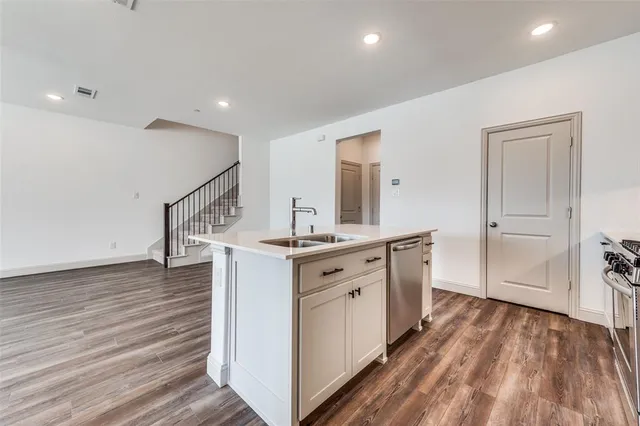 a kitchen with white cabinets and sink