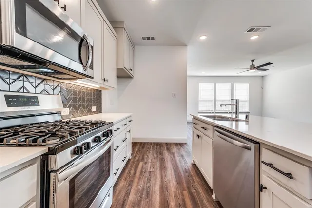 a kitchen with granite countertop a stove and a sink