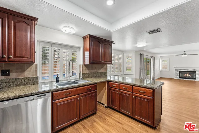 a kitchen with stainless steel appliances granite countertop wooden cabinets sink and stove