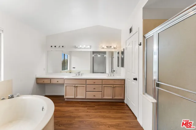 a spacious bathroom with a tub sink and mirror
