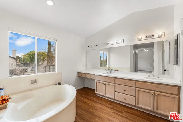 a bathroom with a tub sink and mirror