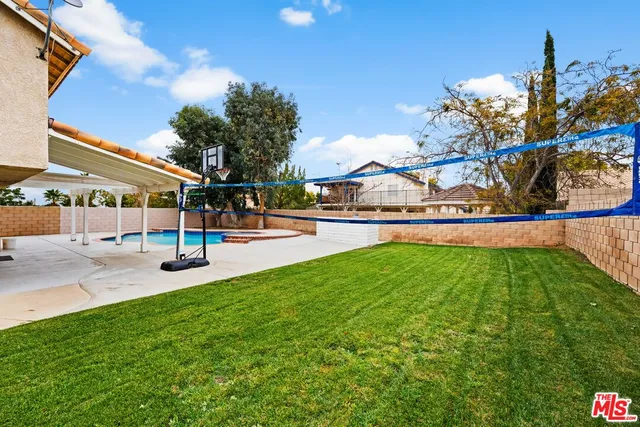a view of yard with swimming pool and seating space