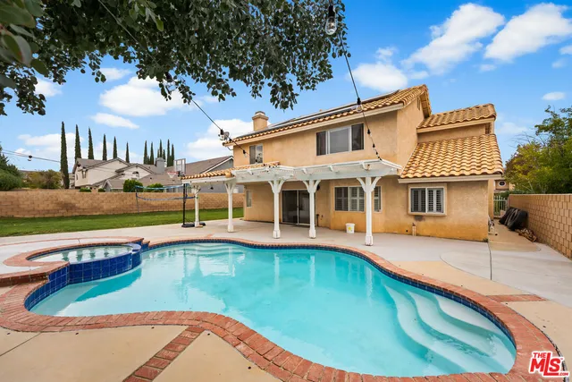 a view of a house with pool and sitting area