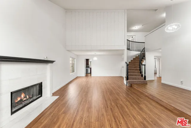 a view of empty room with wooden floor and fireplace