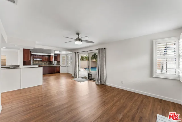 a view of a livingroom with wooden floor and a kitchen space