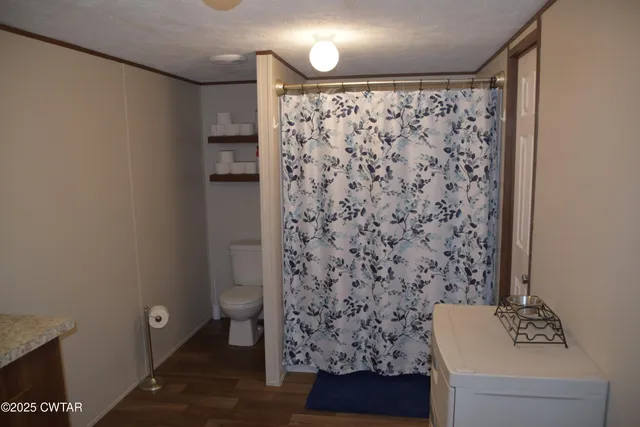 a bathroom with a toilet and a shower curtain