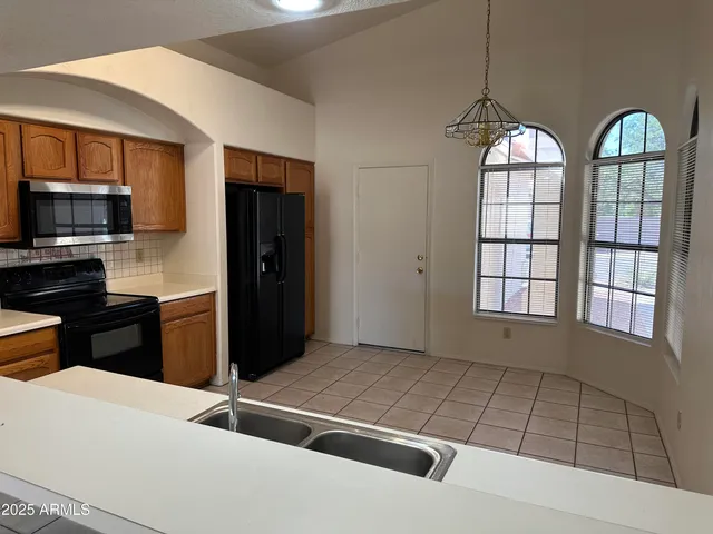 a kitchen with stainless steel appliances granite countertop a refrigerator and a stove top oven