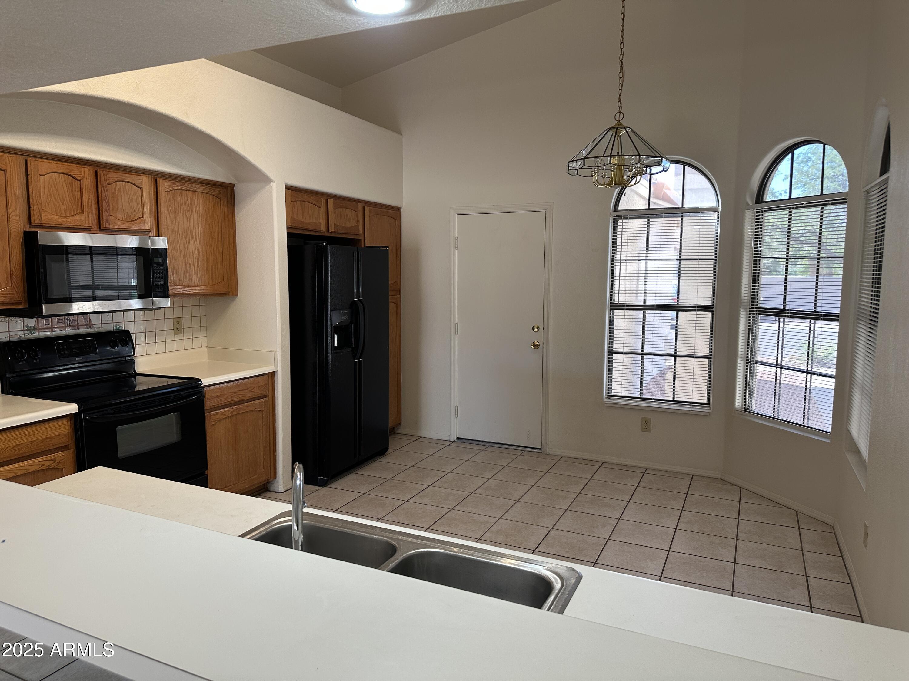 14835 South 26th Way Phoenix, AZ 85048 - Photo 3 of 13 a kitchen with stainless steel appliances granite countertop a refrigerator and a stove top oven