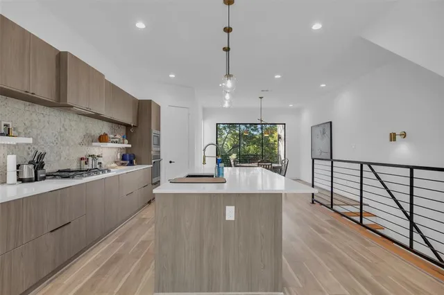 a large kitchen with stainless steel appliances granite countertop a lot of counter space and wooden floors