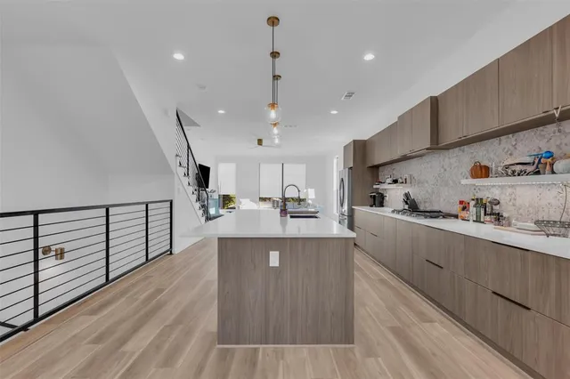 a kitchen with kitchen island a sink a stove and a refrigerator