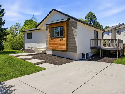 a front view of a house with a yard and potted plants