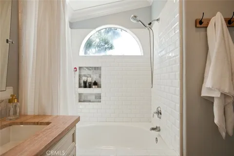 a bathroom with a granite countertop sink a mirror and a bathtub