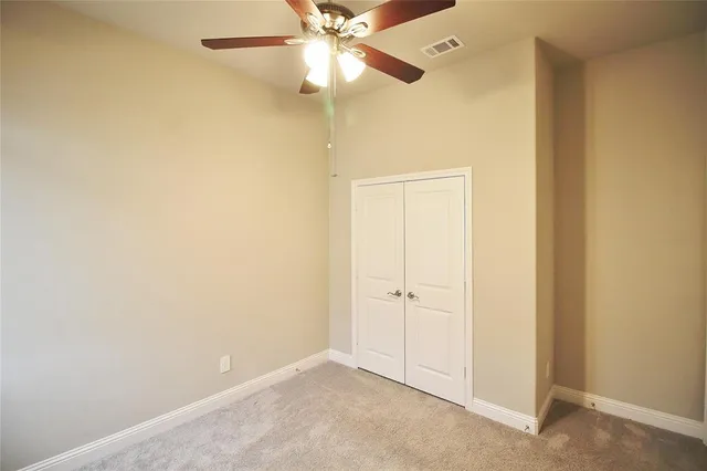 an empty room with a ceiling fan and a window