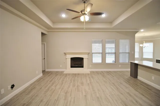 wooden floor fireplace and windows in an empty room