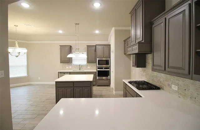 a kitchen with stainless steel appliances a refrigerator and a stove top oven