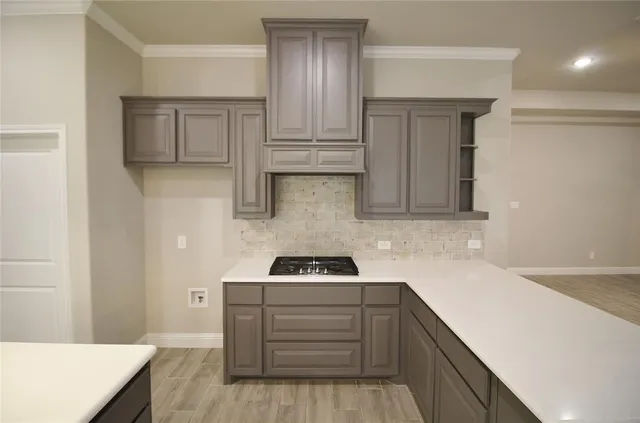 a kitchen with white cabinets and stove