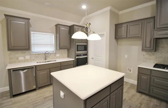a kitchen with a sink dishwasher a stove and a refrigerator with wooden floor