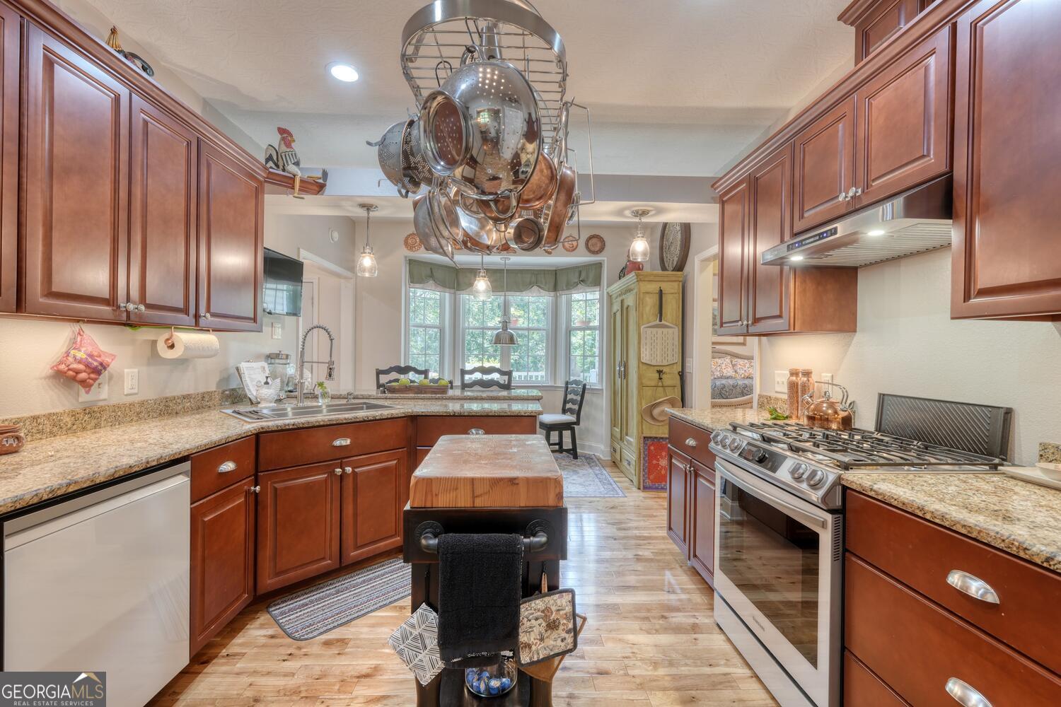 273 Coosa Valley Road Blairsville, GA 30512 - Photo 31 of 34 a kitchen with stainless steel appliances granite countertop a sink a stove and a wooden cabinets