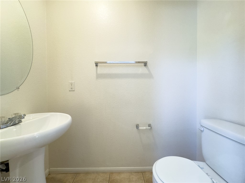 9456 Grandview Spring Avenue Las Vegas, NV 89166 - Photo 18 of 49 A well-maintained bathroom featuring a pedestal sink and tile flooring.