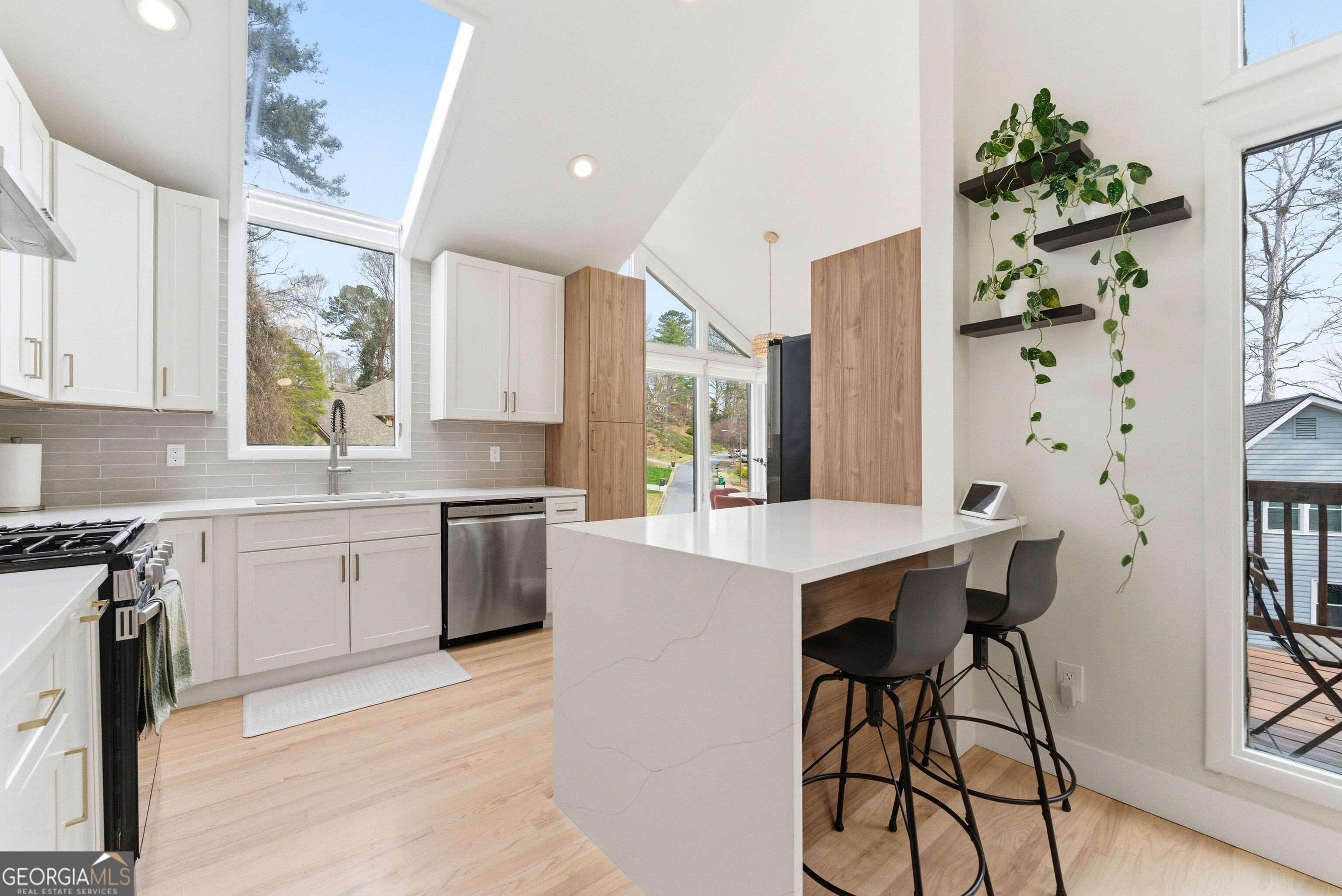 2704 Long Lake Drive Northeast Roswell, GA 30075 - Photo 28 of 48 a kitchen with stainless steel appliances kitchen island a table chairs in it and white cabinets
