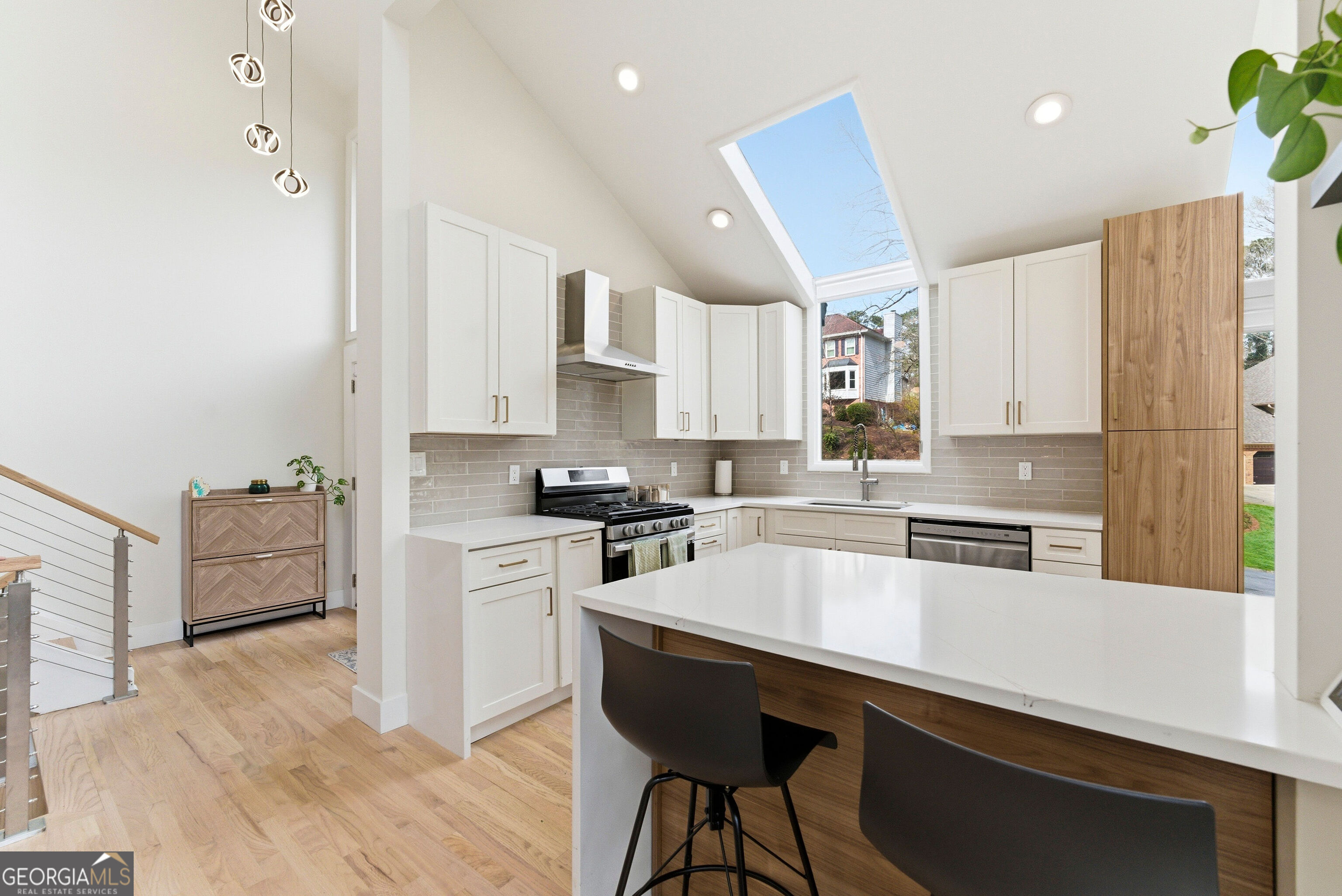2704 Long Lake Drive Northeast Roswell, GA 30075 - Photo 30 of 48 a kitchen with a sink a stove a refrigerator and white cabinets with wooden floor