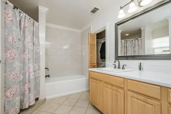 a bathroom with a sink a mirror a bathtub and shower
