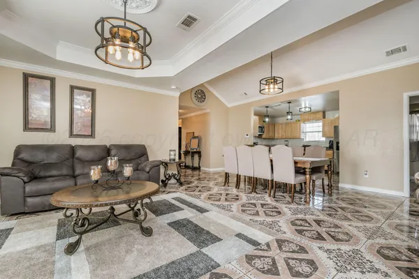 a living room with furniture a dining table and paintings on the wall