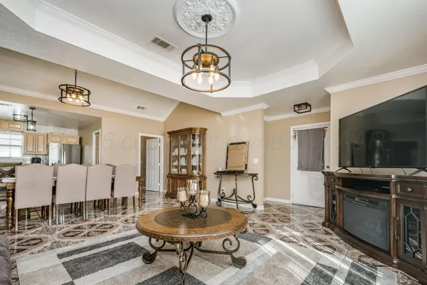 a dining room with wooden floor a chandelier a wooden table and chairs