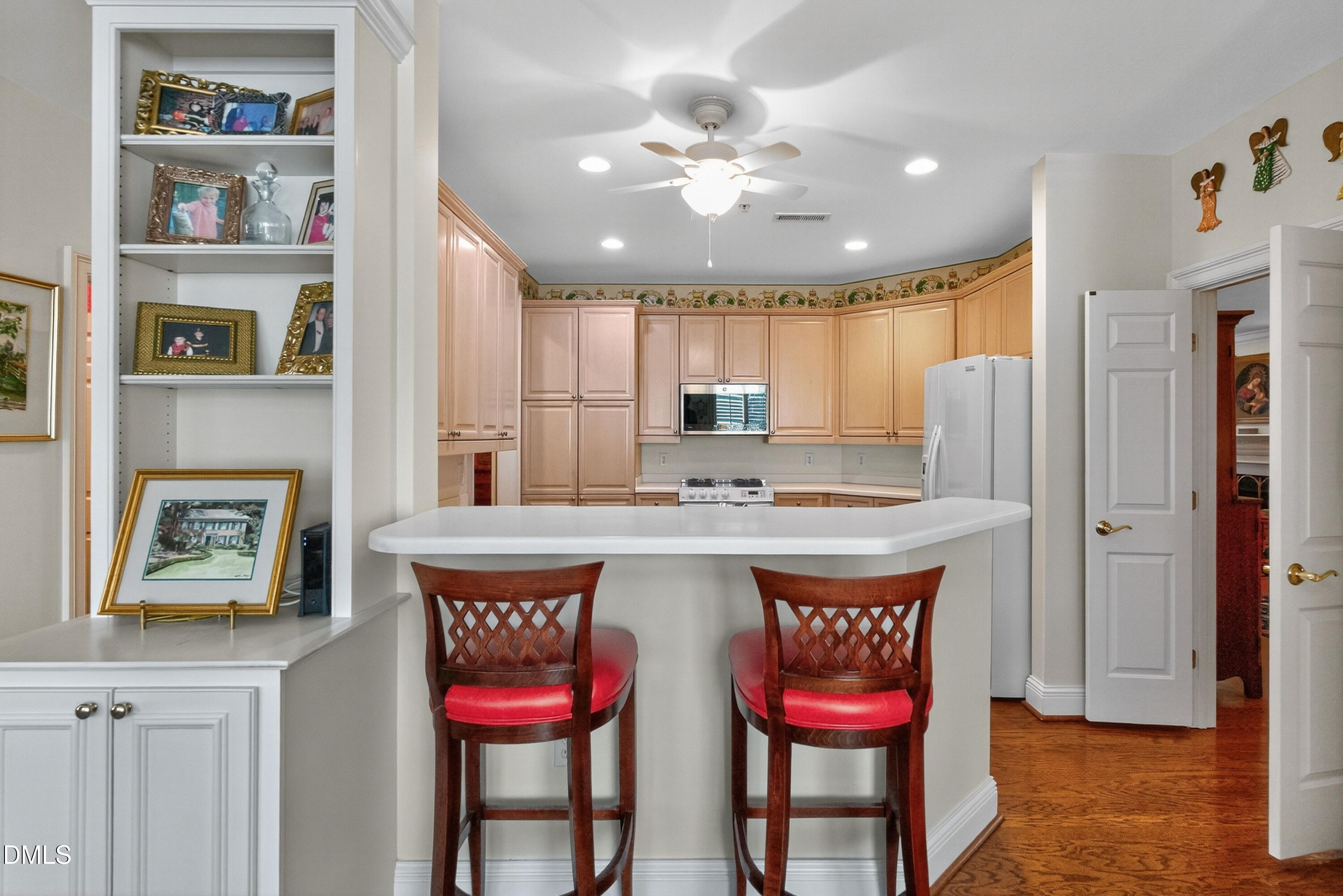 2901 Market Bridge Lane, Unit 104 Raleigh, NC 27608 - Photo 22 of 45 a kitchen with stainless steel appliances granite countertop a kitchen island a stove a refrigerator and a dining table with wooden floor