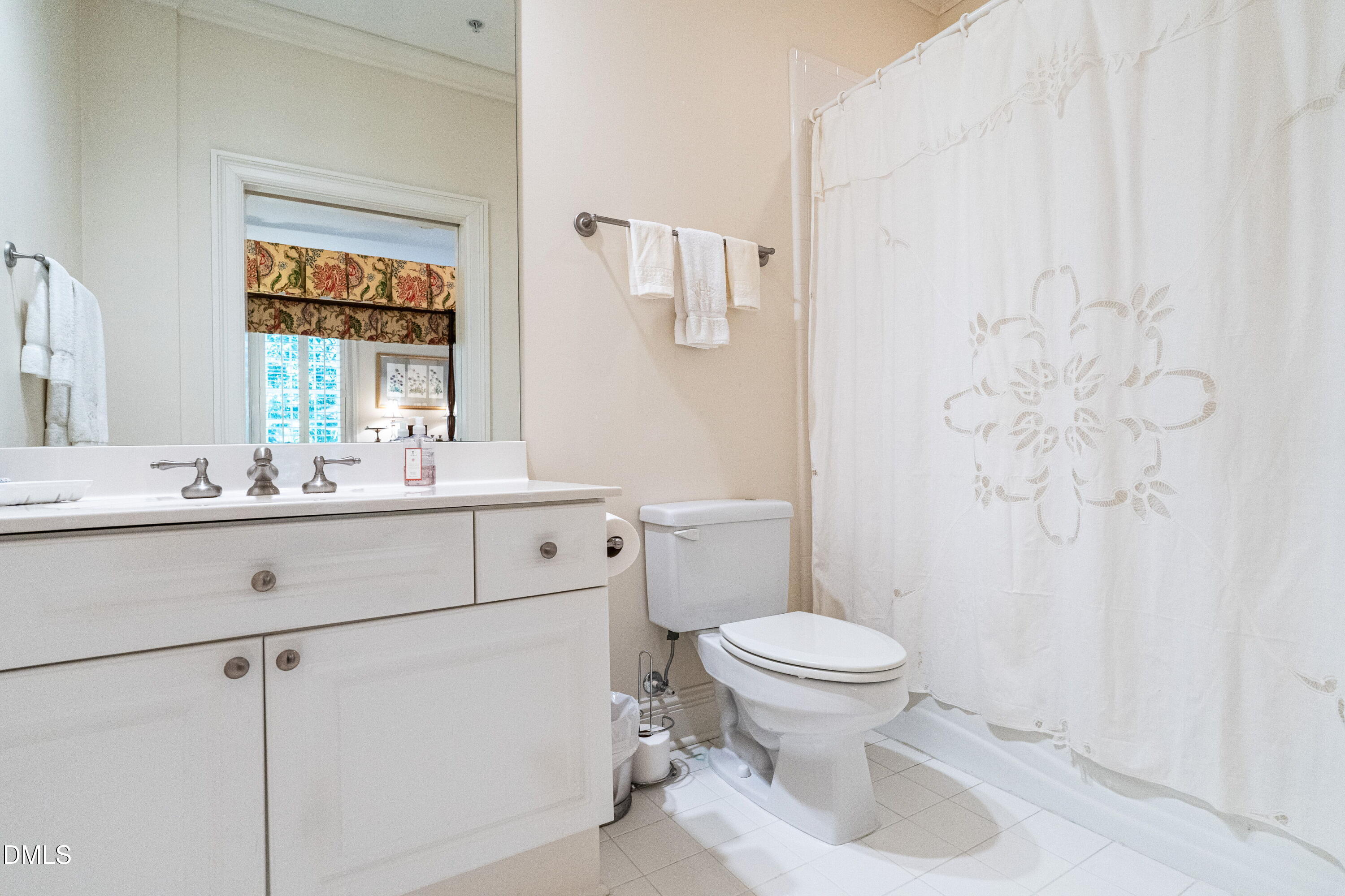 2901 Market Bridge Lane, Unit 104 Raleigh, NC 27608 - Photo 45 of 45 a bathroom with a sink a toilet and a mirror