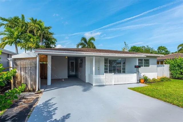a view of a house with potted plants and a large window