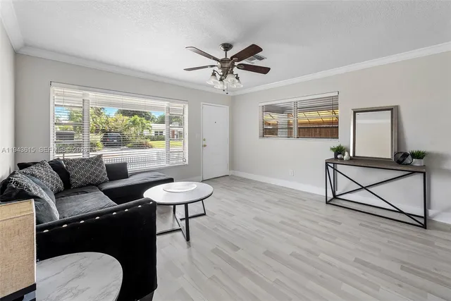 a living room with furniture a window and a ceiling fan
