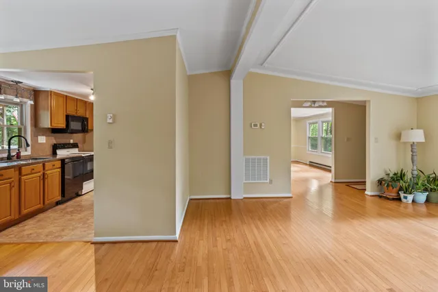 a view of a big room with wooden floor and windows
