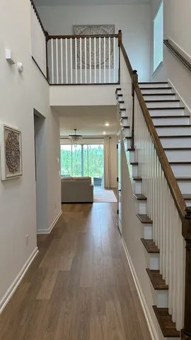 a view of entryway and hall with wooden floor