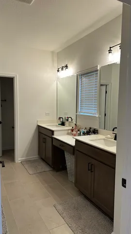 a bathroom with a double vanity sink and a mirror