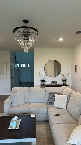 a living room with furniture and a chandelier