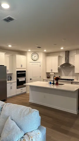 a living room with stainless steel appliances kitchen island granite countertop furniture and a fireplace