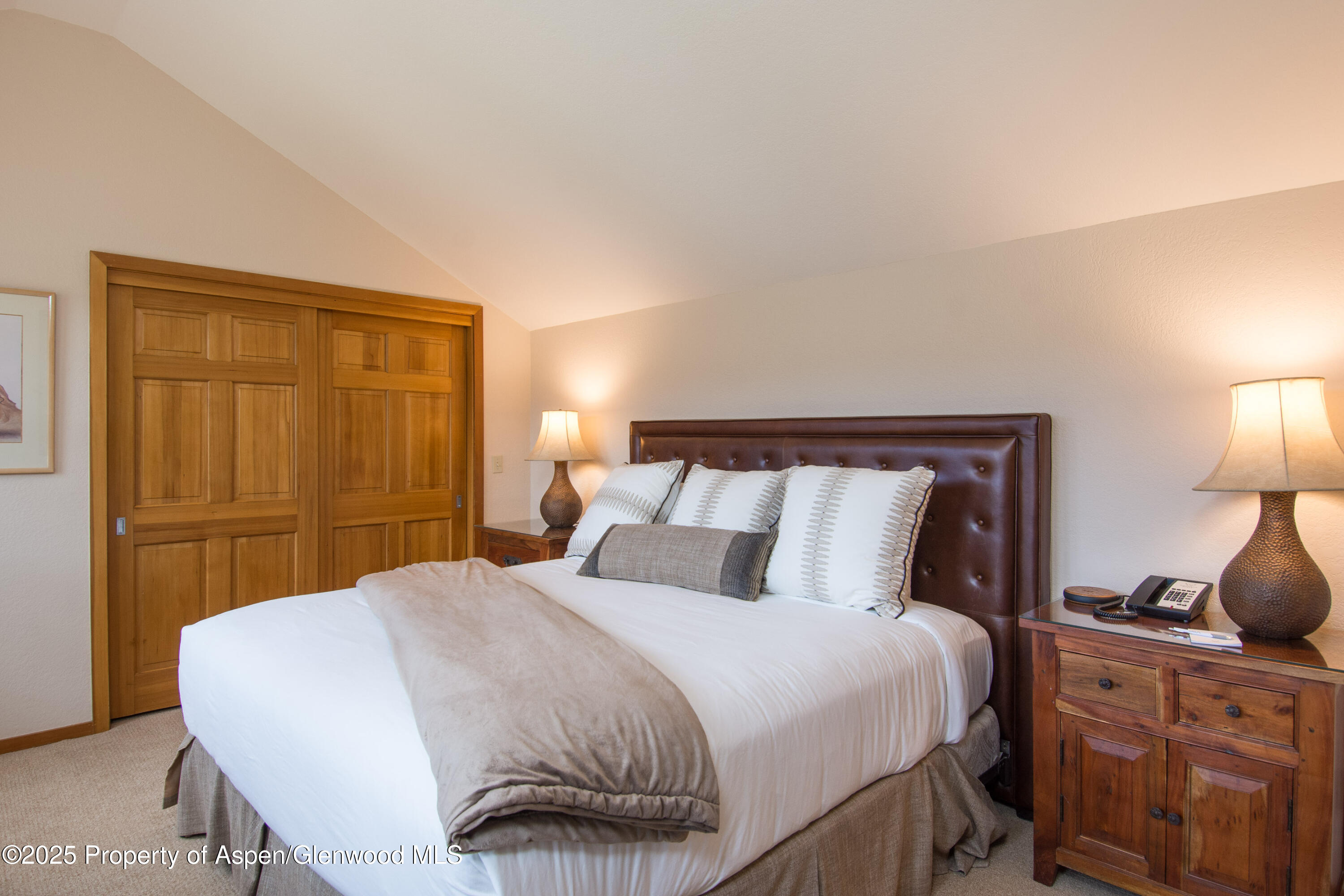 425 Wood Road, Unit 48 Snowmass Village, CO 81615 - Photo 19 of 41 a bedroom with a bed and wooden floor