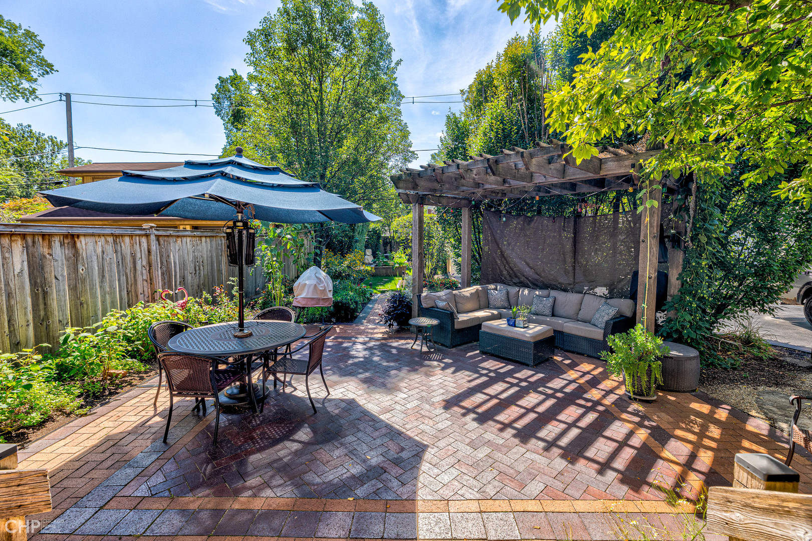 275 Lawton Road Riverside, IL 60546 - Photo 29 of 35 a view of a patio with table and chairs under an umbrella with a small yard