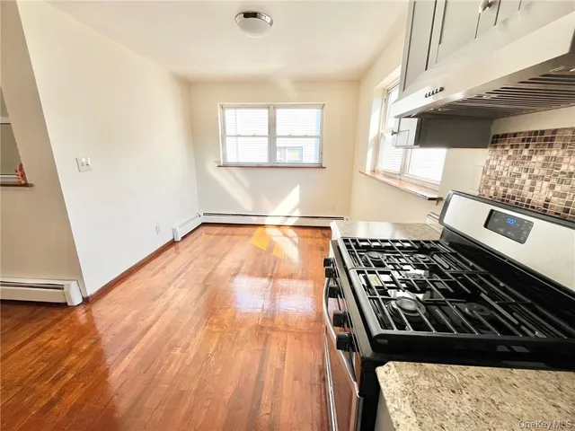 wooden floor in a kitchen next to a window