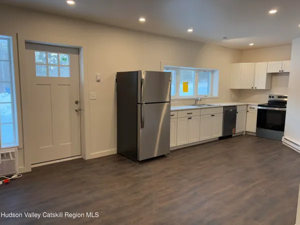 a kitchen with stainless steel appliances granite countertop a refrigerator a sink a stove and oven