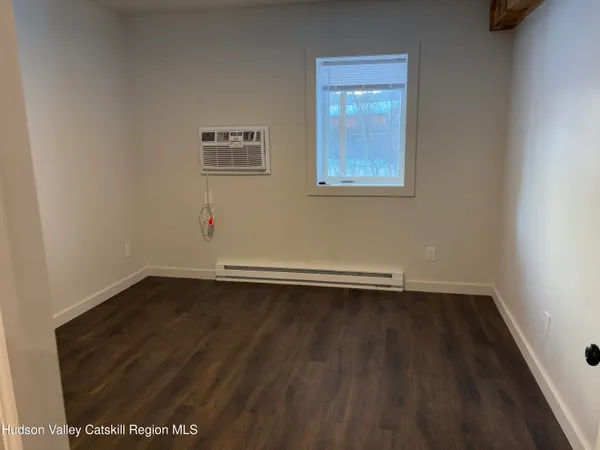 an empty room with wooden floor and window
