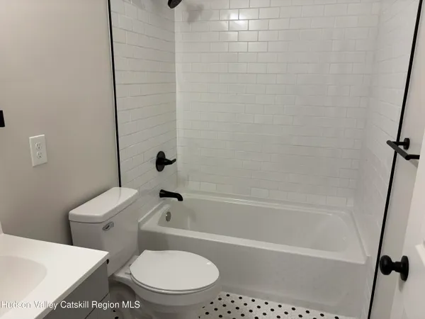 a white toilet and tub sitting next to a bathroom sink