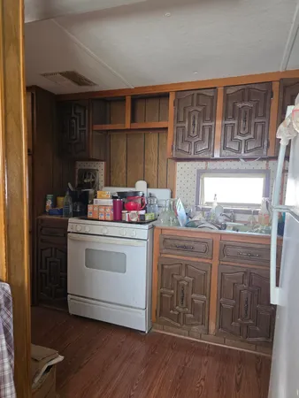 a kitchen with kitchen island a wooden floor and a refrigerator