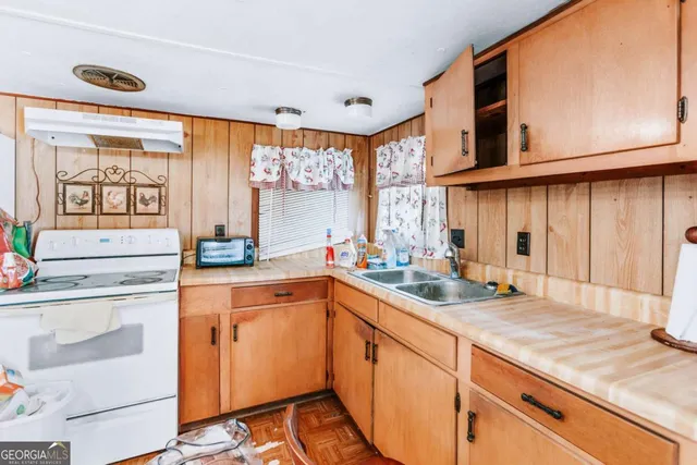 a kitchen with a sink stove and cabinets