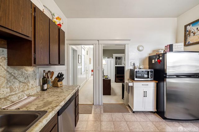 a kitchen with granite countertop a refrigerator and a sink