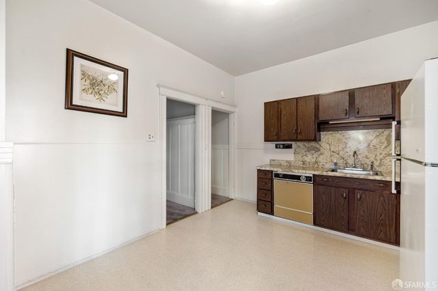 a kitchen with stainless steel appliances granite countertop a stove top oven a sink and dishwasher a refrigerator with wooden floor