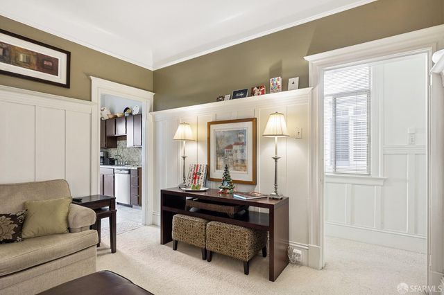 a living room with furniture and a large mirror next to a window